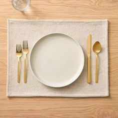 a place setting with silverware on a linen placemat