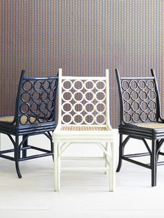 three chairs sitting next to each other in front of a wall