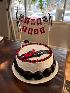 a birthday cake with cars on it and two flags in the shape of race cars