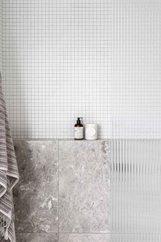 a bathroom with marble walls and white tiles