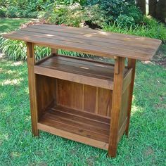 a wooden table sitting on top of a lush green field