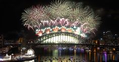 fireworks are lit up in the sky above a bridge