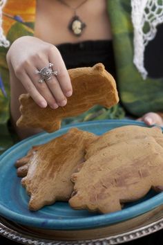 a woman is holding a piece of food on a plate with another item in front of her