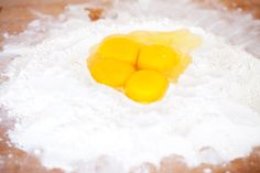 three eggs are in the middle of flour