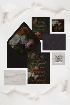 an assortment of wedding stationery and envelopes with flowers on the front, in black paper