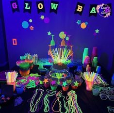 neon glow party supplies and decorations on a table