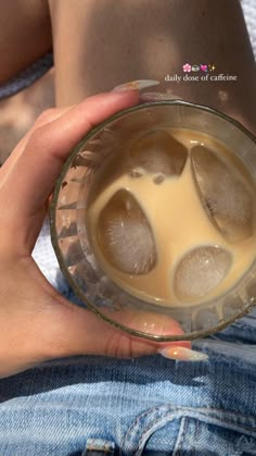 a person holding a glass with some liquid in it