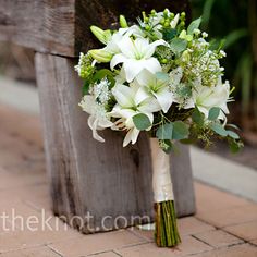 a bridal bouquet sitting on top of a wooden bench