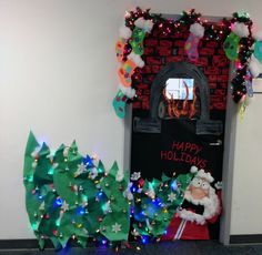 a door decorated with christmas trees and santa's sack in front of a fireplace