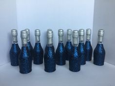 there are many blue bottles with silver caps in the shape of wine bottles that have been placed together