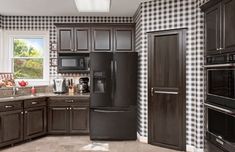 a black and white checkered wall in a kitchen with dark wood cabinets, stainless steel appliances and granite counter tops