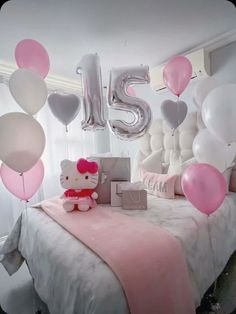 a hello kitty themed room with balloons and presents on the bed, as well as an i love you sign