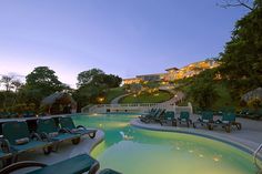 an outdoor swimming pool with chaise lounges and steps leading up to the house