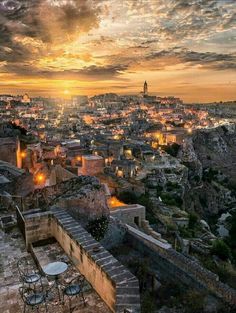 the sun is setting over an old city