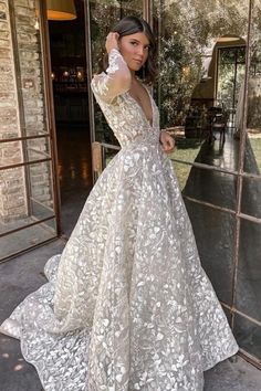 a woman standing in front of an open door wearing a white dress with flowers on it