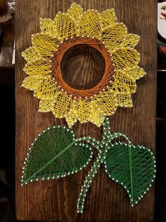 a piece of string art with a sunflower on it