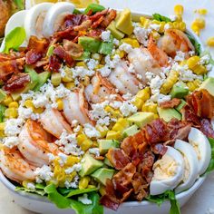 a salad with shrimp, corn, avocado and bacon