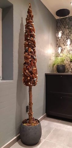 a tall tree made out of donuts in a room next to a wall with lights