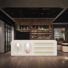 the interior of a restaurant with wooden flooring and white counter tops, along with shelves filled with bottles