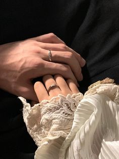 two people holding hands with wedding rings on their fingers