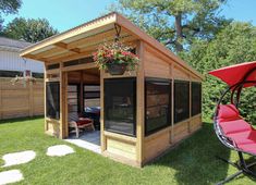 a small wooden shed with a red lawn chair