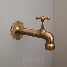 an antique brass faucet is mounted on the wall