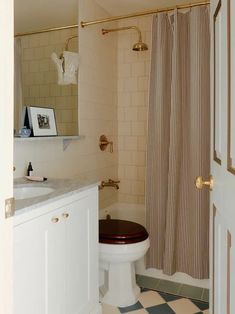 a white toilet sitting next to a shower in a bathroom with black and white checkered flooring