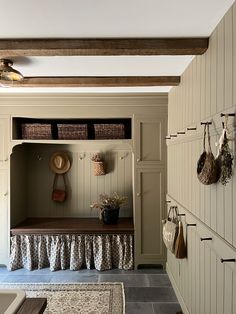 a mud room with some baskets on the wall and other items hanging from the ceiling