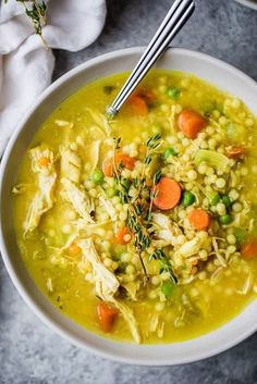 a white bowl filled with chicken and barley soup