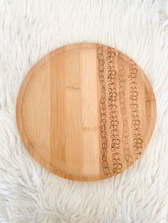 a wooden platter with writing on it sitting on a white furnishing area