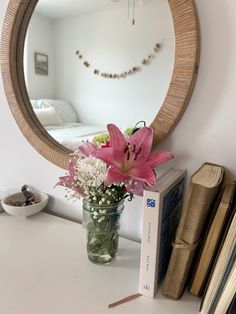 a vase filled with flowers sitting on top of a white table next to a book