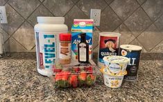 the ingredients for an ice cream smoothie are displayed on the counter top, including yogurt and strawberries