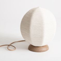 a white ball sitting on top of a wooden stand next to a pair of scissors