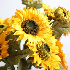 a vase filled with yellow sunflowers on top of a table