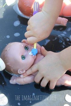 a baby is being fed with a toy