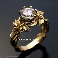 a gold ring with leaves and a diamond in the center on a black surface,