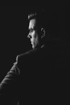 a black and white photo of a man in a suit looking off into the distance