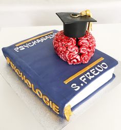 a cake made to look like a book with a graduation cap on top of it