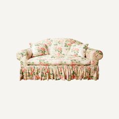 a floral couch with ruffles on the back and pink flowers on the arms