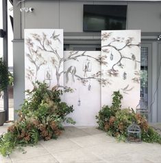 three white panels with birds on them in front of a building