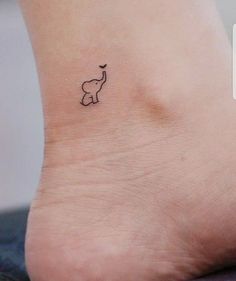 an elephant tattoo on the foot of a woman's left ankle is shown in black ink