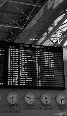 an airport departure board with several clocks on it