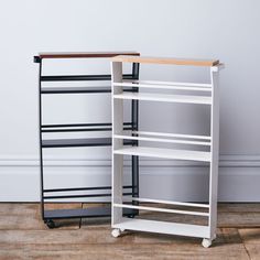 two white shelving units sitting next to each other on top of a hard wood floor