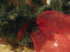 a red mesh bag sitting on top of a counter next to a christmas tree branch