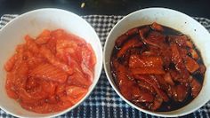 two white bowls filled with cooked carrots on top of a checkered table cloth