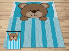 a brown teddy bear laying on top of a blue and white striped bed sheet with a photo next to it