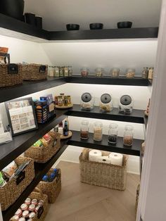 an organized pantry with lots of food items on the shelves and wicker baskets in front of it