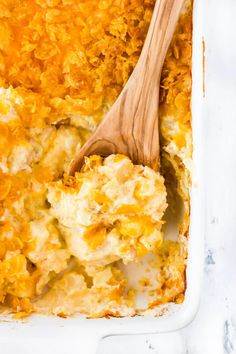 a wooden spoon in a casserole dish with cheese