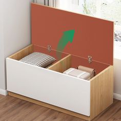 an open storage box on the floor next to a window with a green arrow pointing up