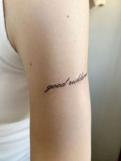 a woman with a small tattoo on her arm that says, good luck in cursive writing